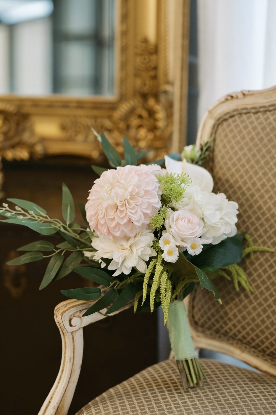 Bridal bouquet of blush and ivory blooms with greenery