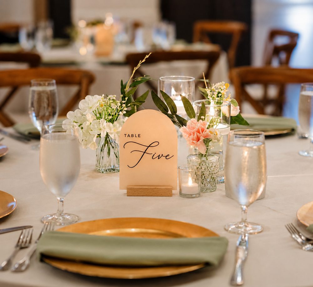 Reception table set with bud vases, candles and a table number card
