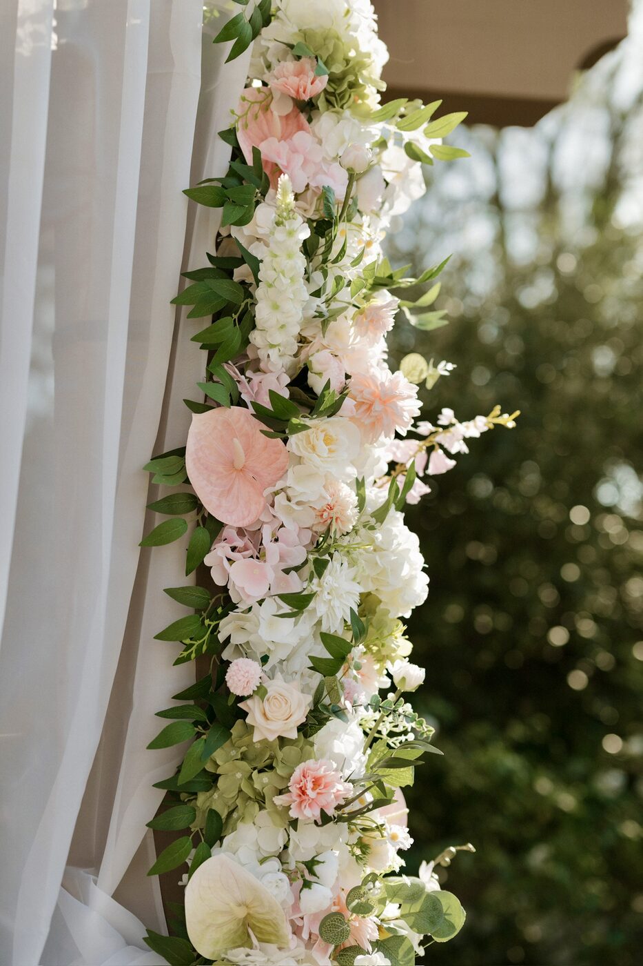 Close-up of a large floral installation in blush, ivory, and greenery